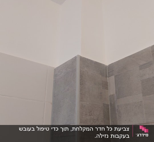 פינת קיר צבועה עם אריחים אפורים ולבנים